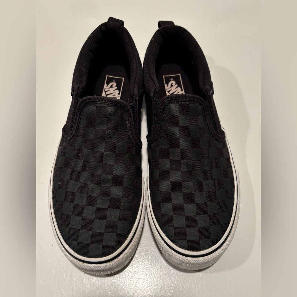 Black on black checkerboard slip on Vans Kid’s size 3.